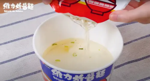 接著將含有麵體的的碗中熱水,倒入已經放入調味粉的碗中。(圖/維力食品YouTube) ▲接著將含有麵體的的碗中熱水,倒入已經放入調味粉的碗中。(圖/維力食品YouTube)