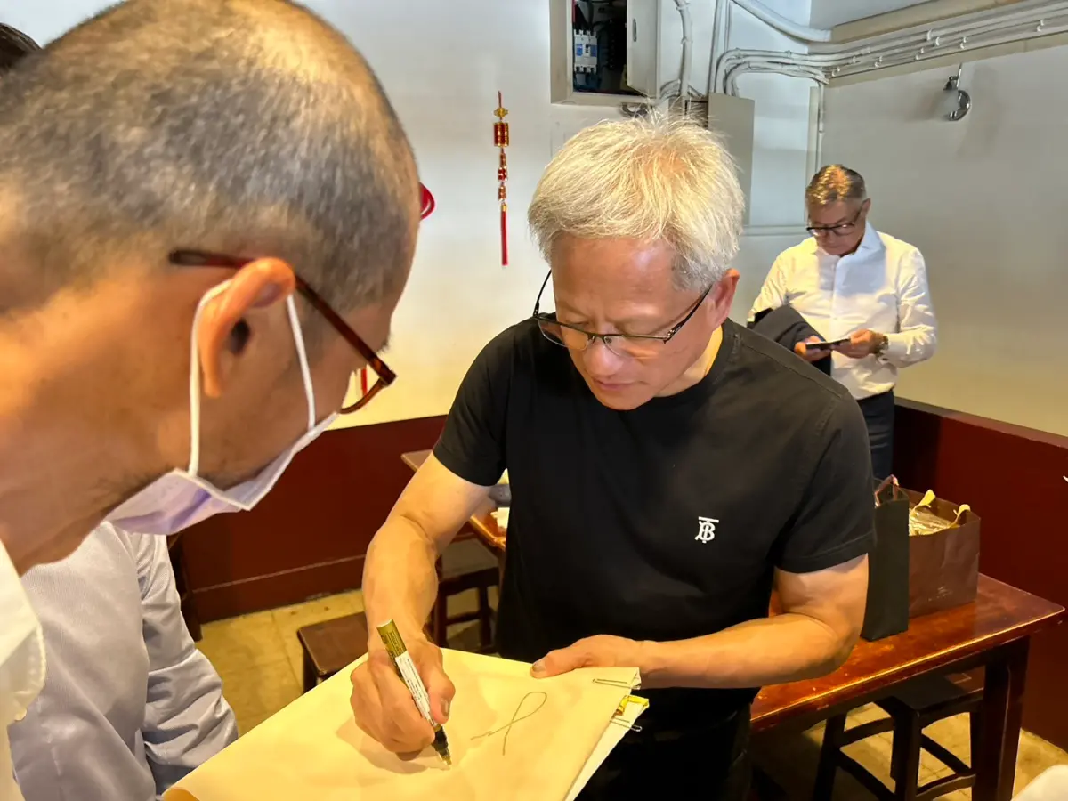 ▲黃仁勳今中午赴愛店「牛耳精緻麵食」用餐，也熱情地幫粉絲簽名。（圖 /讀者提供）