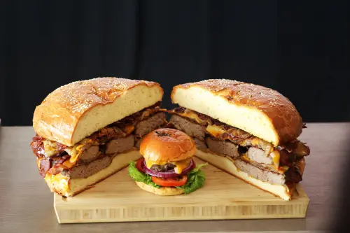 ▲台北萬豪推出10吋大巨人漢堡，重達6公斤，是一般漢堡16倍重量、12倍肉量，圖為與一般尺寸的比較。（圖／台北萬豪提供）