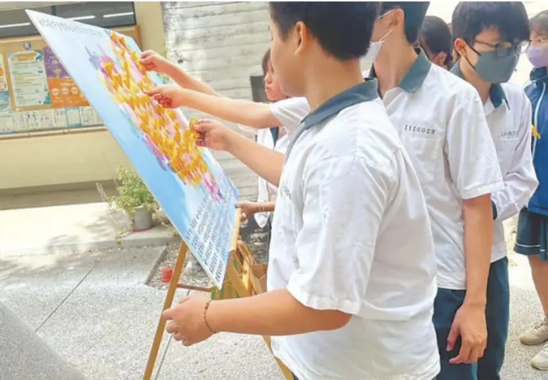 ▲蔡姓國中女老師母校設計「微笑天使」看板，上面繫滿黃絲帶與紙鶴，表達不捨與懷念。（圖／翻攝畫面）