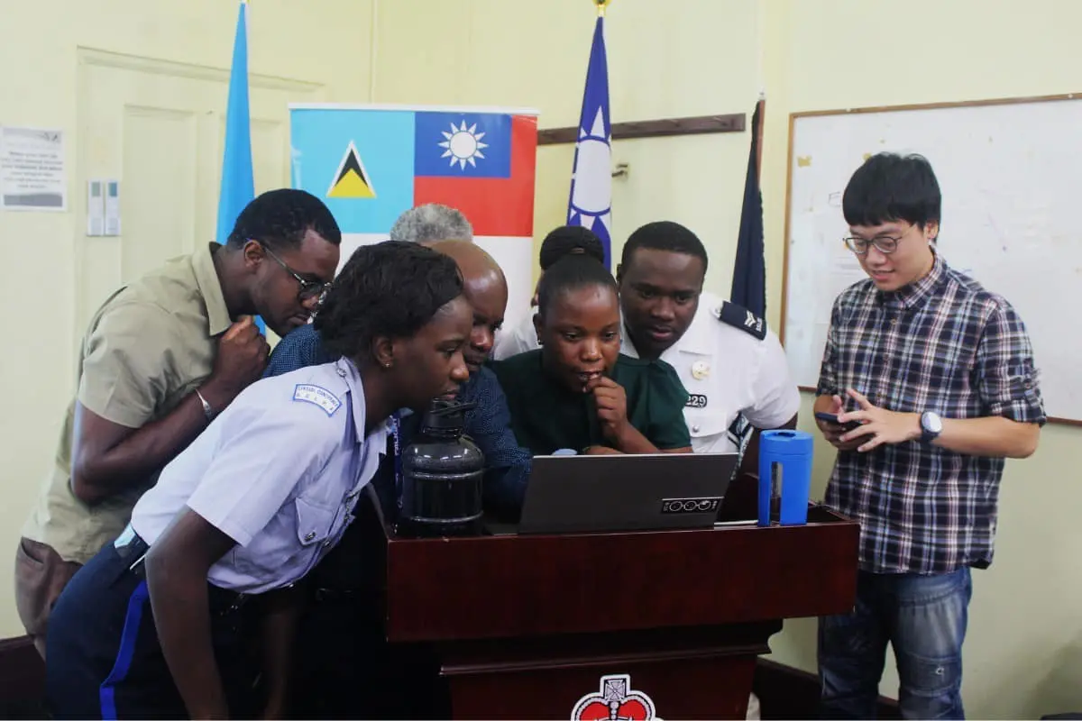 ▲林睿庠（右）服外交替代役期間，教導友邦聖露西亞警察如何應對網路犯罪，如今卻因為經營暗網販毒被捕。（圖／翻攝國發會臉書）