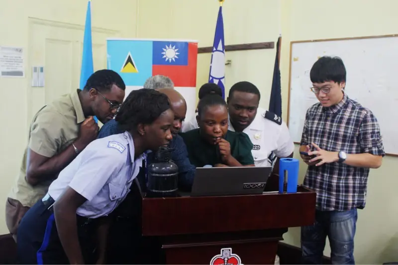 ▲林睿庠（右）服外交替代役期間，教導友邦聖露西亞警察如何應對網路犯罪，如今卻因為經營暗網販毒被捕。（圖／翻攝國發會臉書）