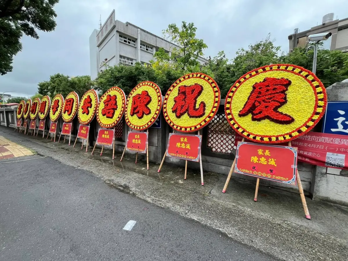 ▲6月迎來畢業季，高雄一名爸爸特別大手筆買了11個花圈擺在校門口，送給女兒當畢業禮物，引起社群討論。（圖/高雄點臉書）