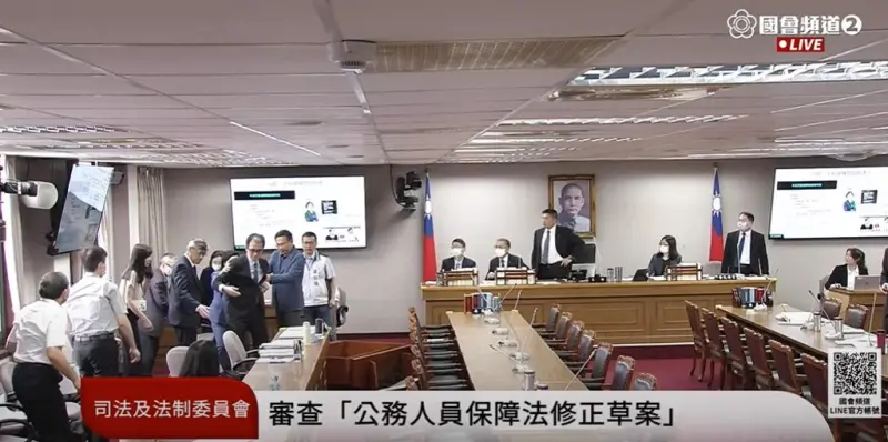 ▲考試院秘書長劉建忻接受備詢時，臉色發白，隨後昏厥倒地，撞倒質詢台。（圖／翻攝國會頻道）