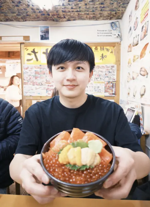 ▲吉他手阿哲去北海道旅遊，不忘用鮭魚卵來創意催票。（圖／何樂音樂提供）