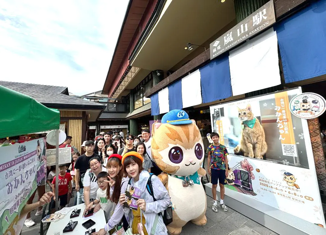 ▲高雄捷運公司蜜柑站長快閃日本京都嵐電嵐山站首賣活動，吸引來自我國、日本及各國粉絲到場，開心與大蜜柑合影留念。(圖／高雄捷運公司提供)
