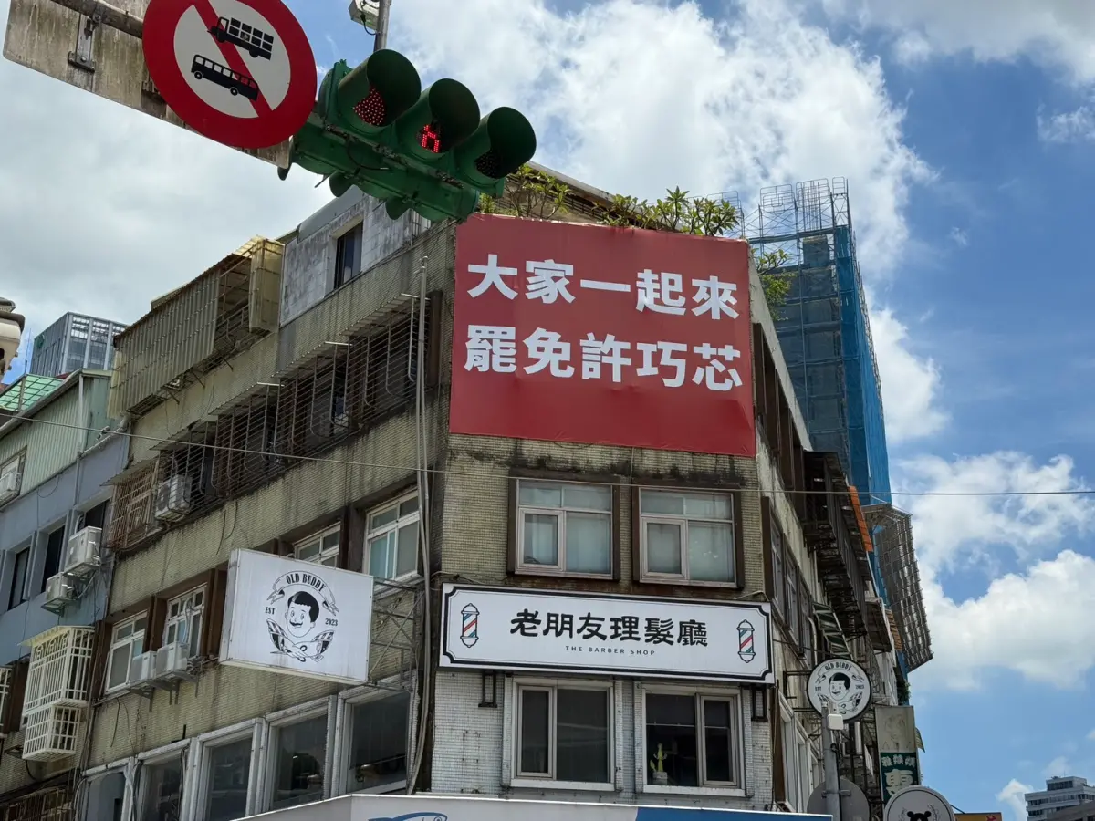 ▲北市信義區永吉路30巷與松隆路交叉口建築物罷免徐巧芯的布條，因為遮蔽窗戶有公安疑慮，遭建管處限期改善。（圖／北市建管處提供）