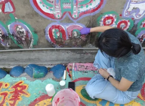 ▲台中市政府文化局聘請專家修護「彩虹眷村」彩繪牆面污損情況。（圖／台中市政府提供，2025.06.10）