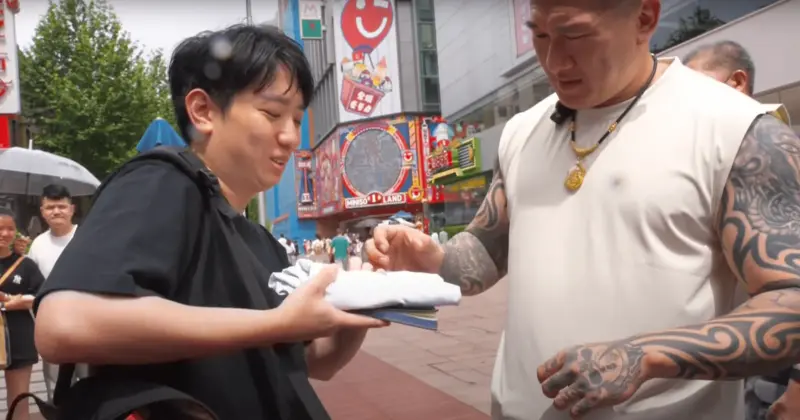▲小草拿出柯文哲的競選小物「KP Tshirt」，要求館長幫簽名。（圖／翻攝自YouTube館長惡名昭彰）