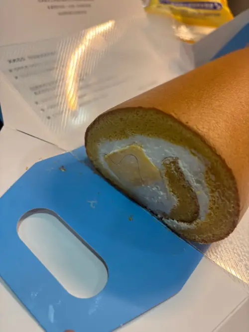 ▲民眾昨（14）日在新北大坪林捷運站的亞尼克販賣機購買生乳捲，出現「捲捲的毛」。（圖／翻攝畫面）