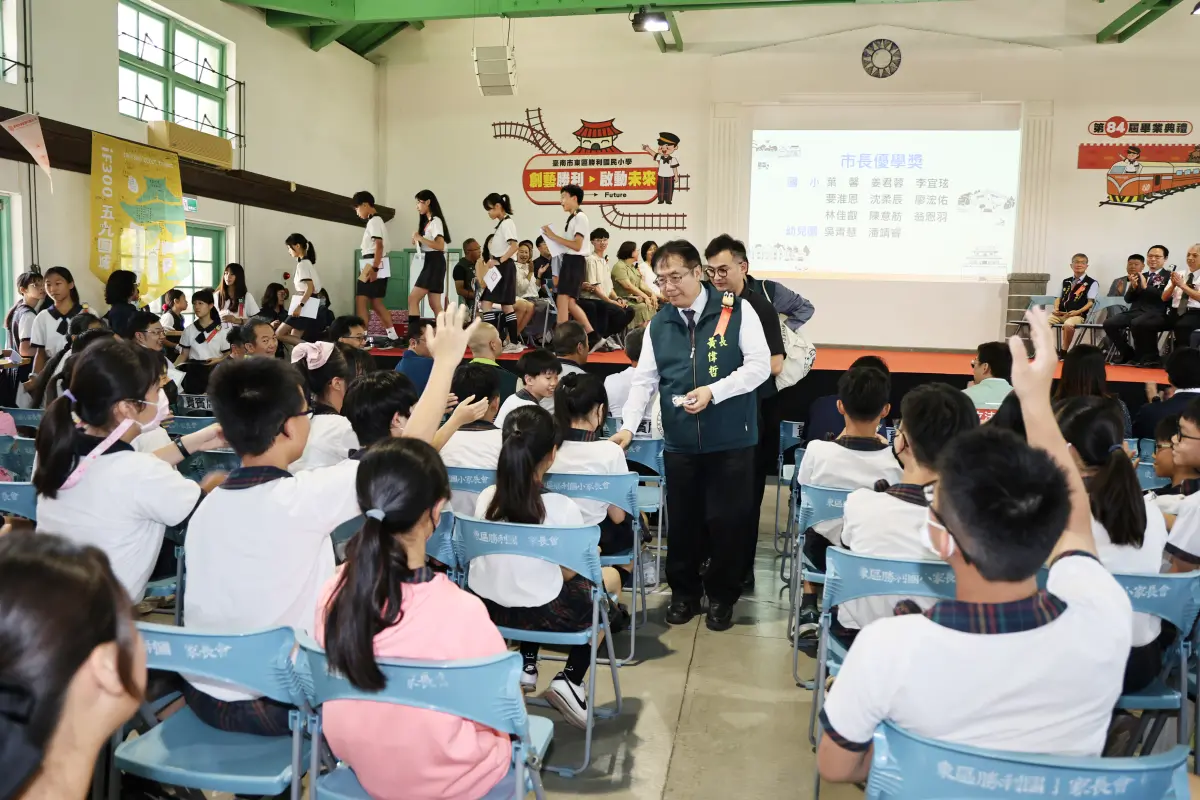 ▲台南市長黃偉哲參加國中小畢典大方撒禮物，網友表示好像在餵魚。（圖／臺南市政府提供）