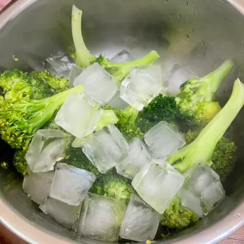 ▲川燙過後的花椰菜放入冰塊中冰鎮，再把花椰菜放進食品夾鏈袋冷凍。（圖／廚藝公社）