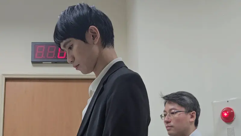 ▲Andy在保全櫃檯前站著等開庭,神情轉為凝重,從頭到尾都沒回頭看家寧一眼。(圖/記者劉松霖攝)
