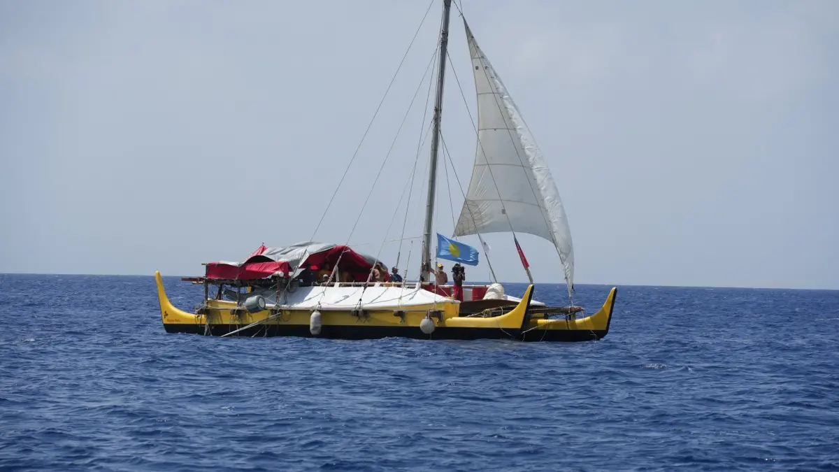 ▲帛琉原住民與達悟族人在蘭嶼海岸合力牽引手作獨木舟登岸。（圖／翻攝自臉書）