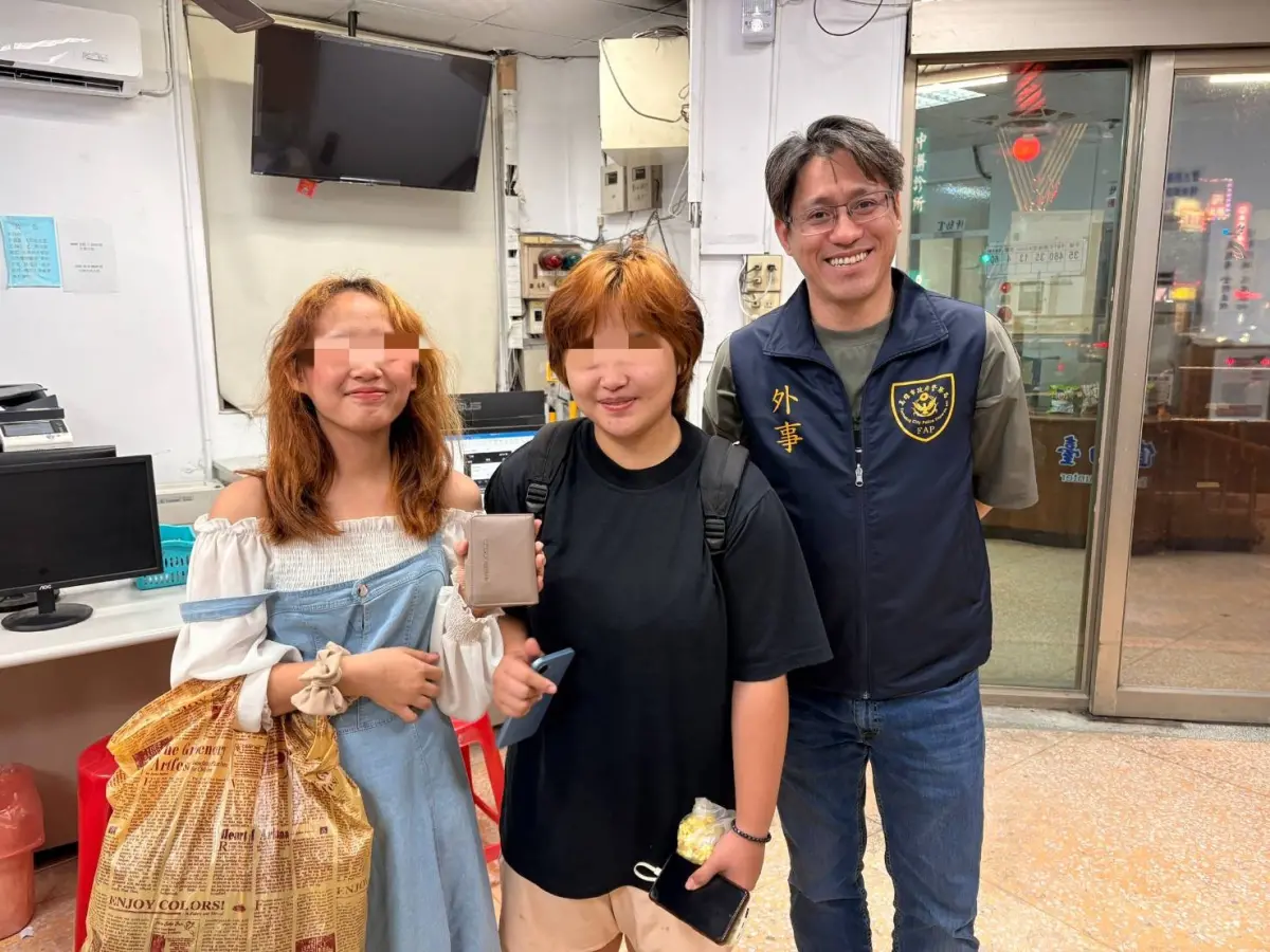 ▲菲國外籍生(左)偕友人尋獲皮夾後與外事警員葉俊偉(右)開心合影。(圖／高市警局提供)