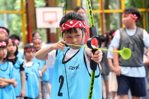 ▲小朋友在老師引導下學習射箭技巧，不但比誰射得準，更比誰笑得開懷