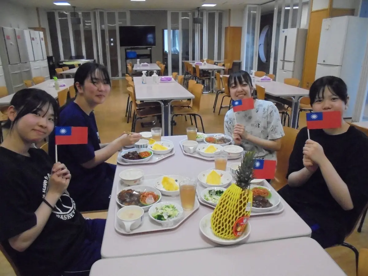 ▲北海道美唄市高中生們手拿我國國旗，邊品嘗鳳梨邊露出開心燦爛的笑容，大家都表示鳳梨非常美味。（圖／南市府提供）