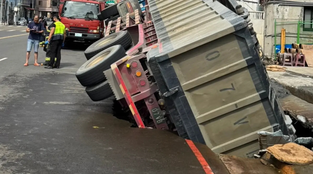 ▲新北三重龍門路一處工地前路面崩塌，導致一輛砂石車陷落卡住。（圖／警方提供）