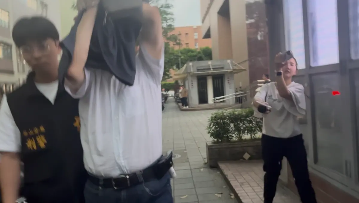 ▲地球村美語負責人陳中義（白衣男）涉嫌教唆竹聯幫靜安會恐嚇與他有債務糾紛的女牙醫，警方將他移送台北地檢署。（圖／翻攝畫面）