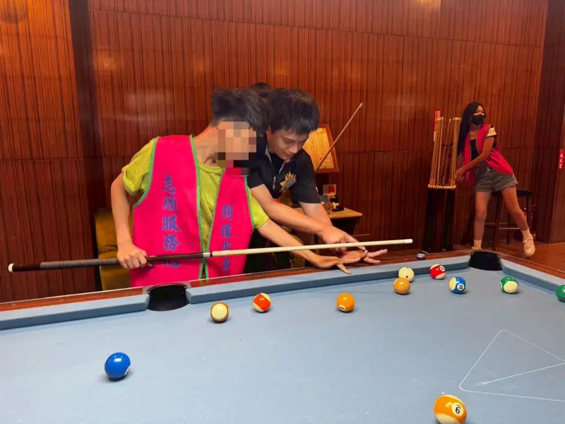 ▲高市警局少年隊及少年輔導委員會結合NICE耐斯撞球館於28日辦理「一日撞球少年」。活動中少年隊警官們陪伴學員練習。(圖／高市警局少年隊提供)