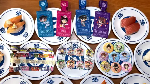 ▲電影《名偵探柯南：獨眼的殘像》上映，7月4日開搶藏壽司聯名，20款扭蛋徽章、裝飾掛飾、紙膠帶，及4款行李吊牌滿額贈品。壽司郎hololive EN即起「盲袋胸章」隨餐附贈，開搶A4資料夾。（圖／藏壽司提供）（圖／藏壽司提供）