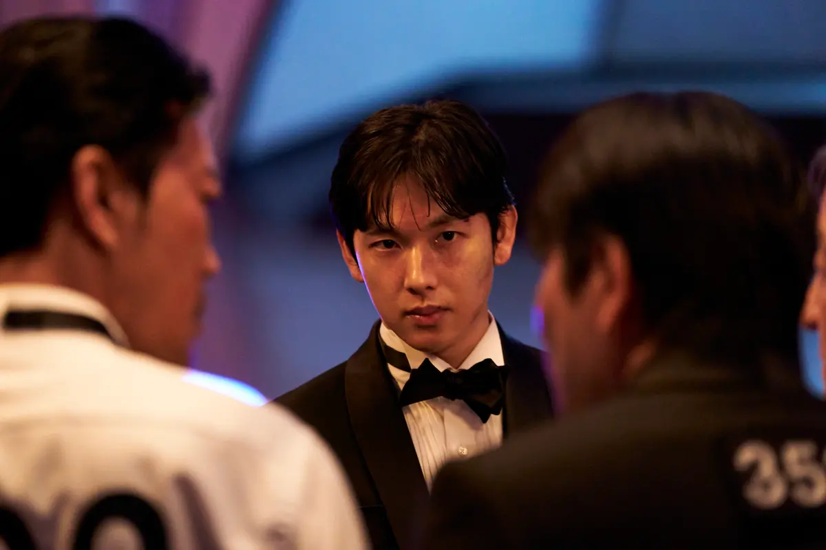 ▲在《魷魚遊戲3》飾演編號333李名器的任時完（如圖），是個超會唱跳的藝人，因為他曾是男團ZE:A（帝國之子）成員之一，表演「少女時代」金曲都難不倒他。（圖／Netflix）