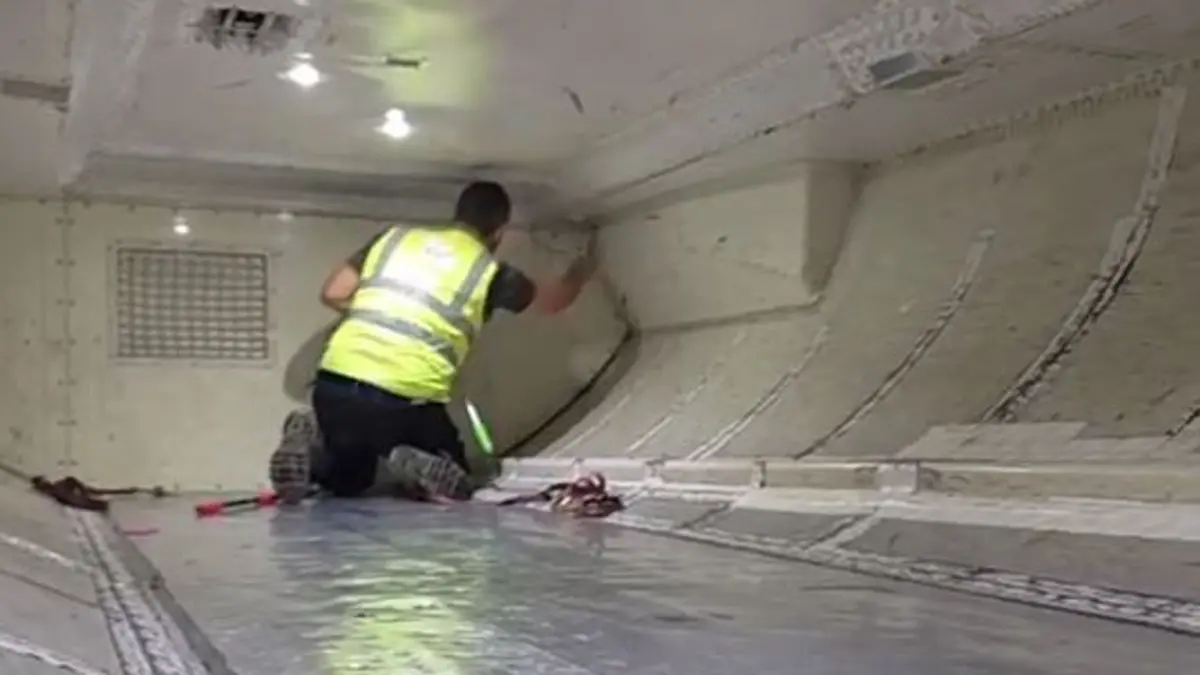 ▲維珍澳洲航空班機的客艙內發現一條蛇，捕蛇專家在千鈞一髮之際，避免蛇從面板縫隙鑽進，免除須拆飛機的命運。（圖／翻攝自Ｘ）