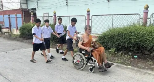 泰國截肢僧人誦經途中電動輪椅打滑跌入水溝 學生與民眾合力救援