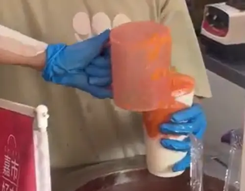 ▲穀壹綠豆沙專門店店員藉由杯子挖起大量的木瓜冰沙。（圖／Google評價）