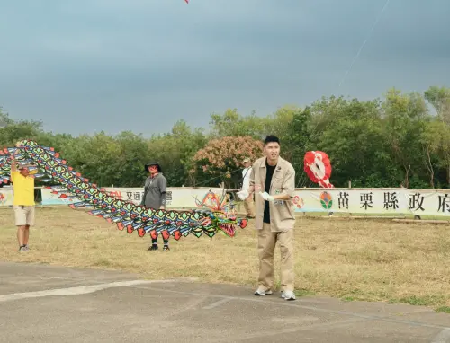 ▲胡釋安在苗栗風箏節嘗試放巨龍風箏,大嘆真的沒有想像中簡單。(圖/客家電視提供) ▲胡釋安在苗栗風箏節嘗試放巨龍風箏,大嘆真的沒有想像中簡單。(圖/客家電視提供)