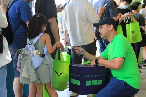 ▲當天除了大人排隊，也有小朋友陪著家人一起排，貼心的門市人員見狀，也不忘蹲下身子跟這位小小客人互動。