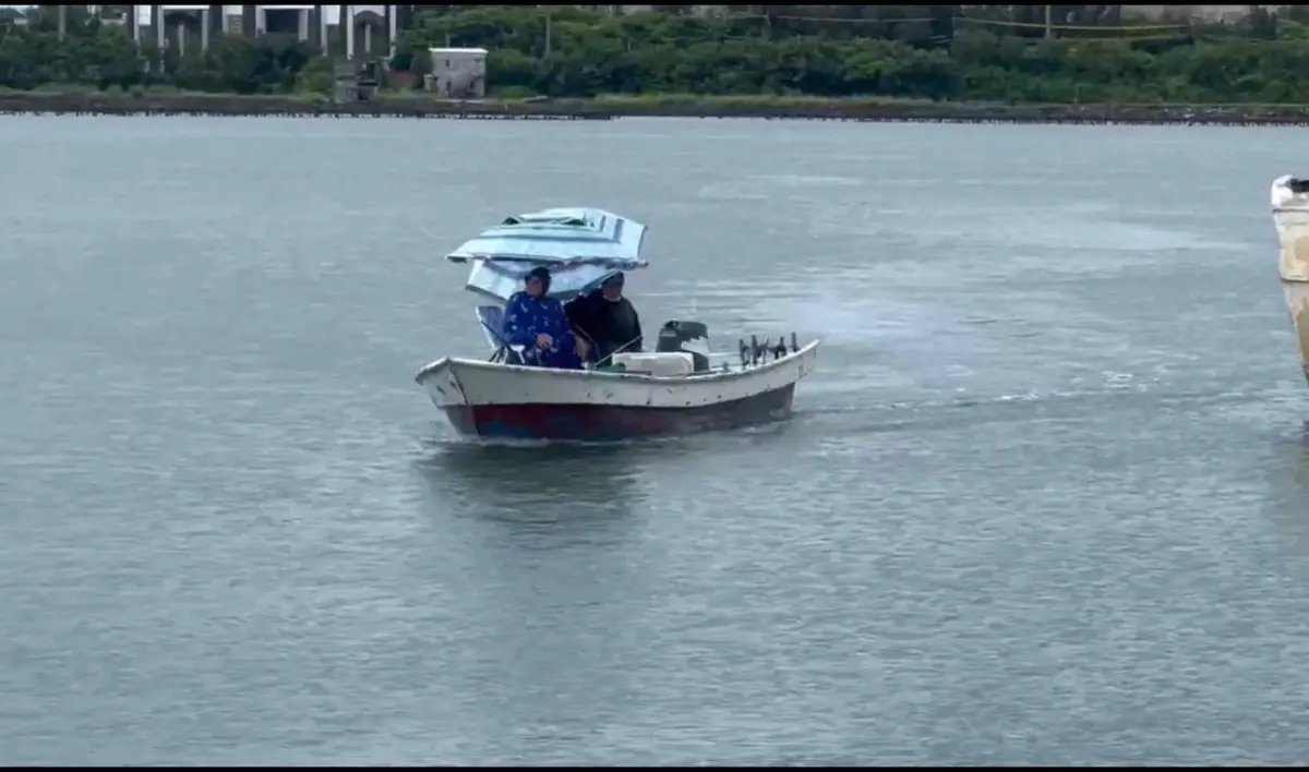 ▲2名民眾在中颱丹娜絲來襲期間，跑到達興漁港搭乘船型浮具在港區，疑似從事垂釣，被海巡人員立即戒護上岸。（圖／海巡署提供）