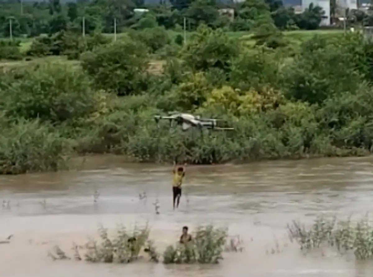 ▲越南日前發生孩童受困湍急河流中間，農夫出動遙控無人機營救的畫面。（圖／截取自影片）