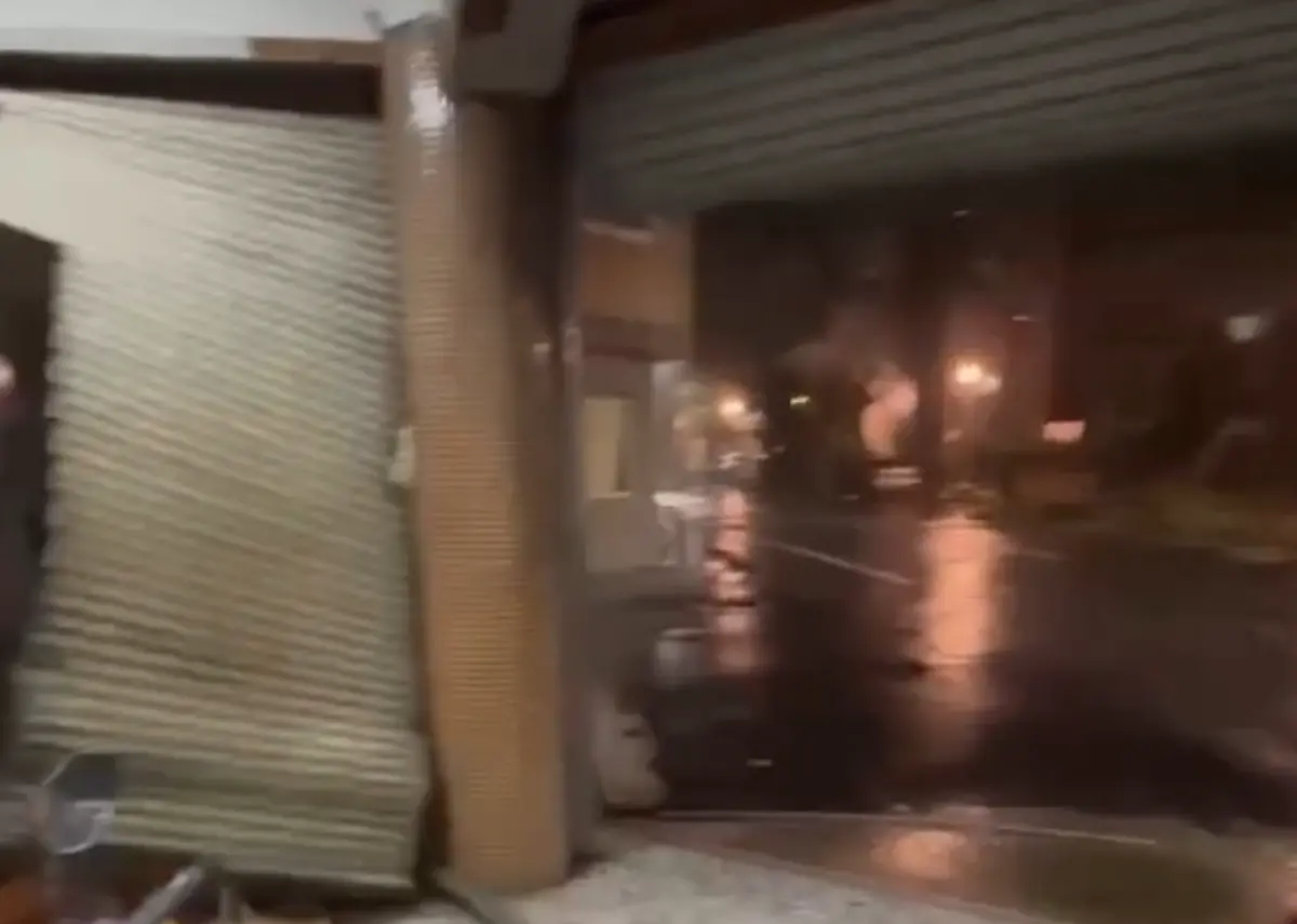 ▲台南居民分享鐵捲門被吹起的影片，部分網友質疑鐵捲門裝設在騎樓是違建，不但沒同情，還諷刺颱風很貼心。（圖／翻攝臉書）