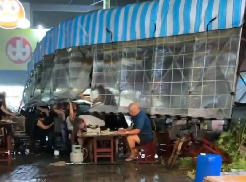 ▲有台南民眾目擊一家路邊小吃攤棚架，在風雨中應聲倒塌，現場一位阿伯卻淡定地坐在塑膠椅上繼續用餐，讓全場看傻。（圖／翻攝自Threads@ding19940614）