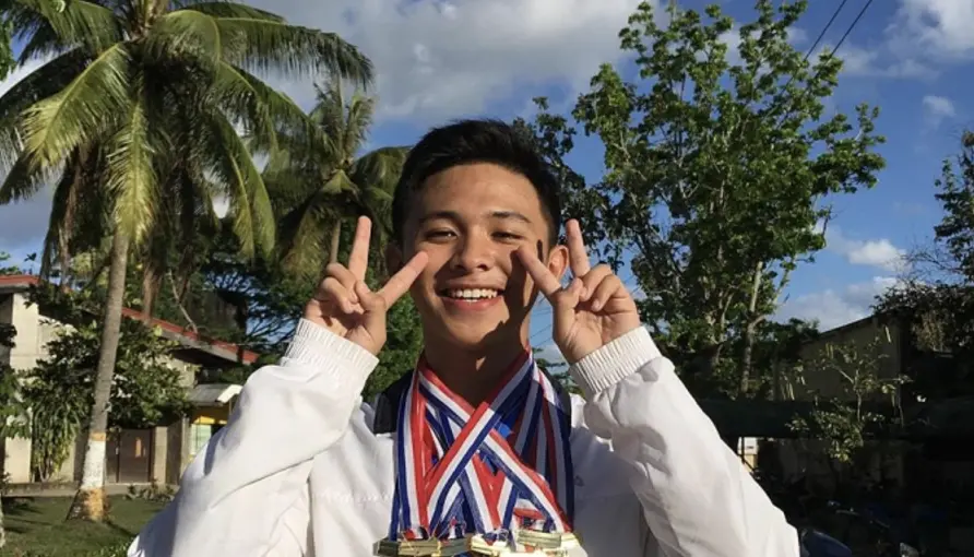 ▲乞討麵包維生的菲律賓少年尤金（Eugene Dela Cruz），如今以傲人成績畢業於菲律賓頂尖學府，他也因此知名度大開。（圖／翻攝自臉書）