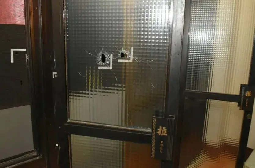 ▲50歲陳姓毒蟲7日晚間在家試霰彈槍，並往對面鄰居2樓開槍，導致神明廳的窗戶破損、牆面出現彈孔。（圖／警方提供）