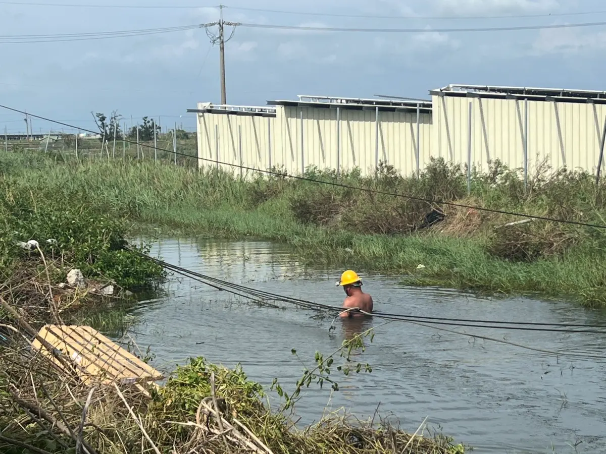 ▲丹娜絲颱風重創南台灣，嘉義、台南部分地區尚未復電，台電員工連日來緊急搶修，其中一名員工為了拉起電線桿泡在水中，引來妻子含淚喊話「是我老公！」（圖／蔡易餘臉書）