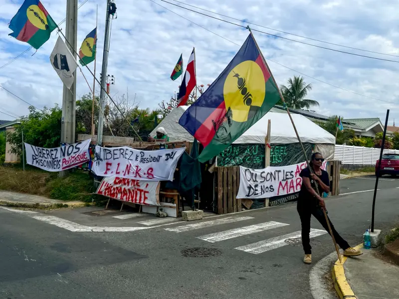 ▲法國與南太平洋海外屬地「新喀里多尼亞」達成歷史性協議,將成立新國家「新喀里多尼亞國」,但立國後仍屬法國。圖為一名原住民卡納克人高舉獨立旗幟。(圖/美聯社/達志影像)