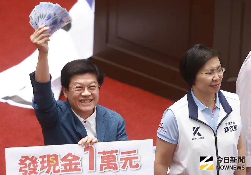 ▲立法院7月三讀通過《因應國際情勢強化經濟社會及民生國安韌性特別條例》，明文規定普發現金1萬元，國民黨立委羅明才手拿10張千元大鈔教數數。（圖／記者葉政勳攝，2025.07.11）