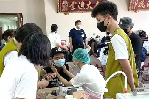 ▲國境事務大隊高雄港隊舉辦外籍船員義診義剪活動，對外籍船員義診的情形。(圖／移民署高雄港隊提供) 