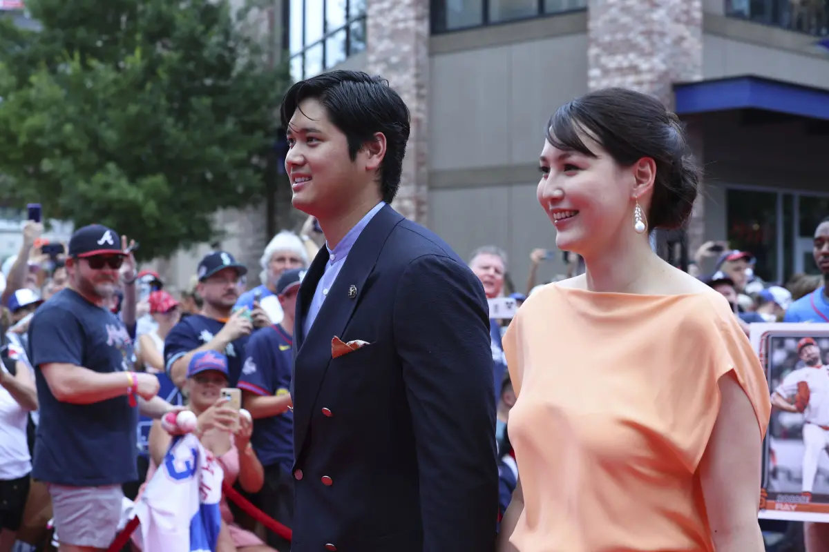 ▲ 洛杉磯道奇日本二刀流球星大谷翔平與愛妻田中真美子於明星賽前走紅毯大道，這也是真美子在今年4月迎來愛女後，產後首度公開亮相，大谷身穿海軍藍西裝搭配前淺藍色襯衫，而真美子則是身穿喬治亞州水蜜桃色為主的的橙色禮服亮相，展現十足氣質。（圖／美聯社／達志影像）