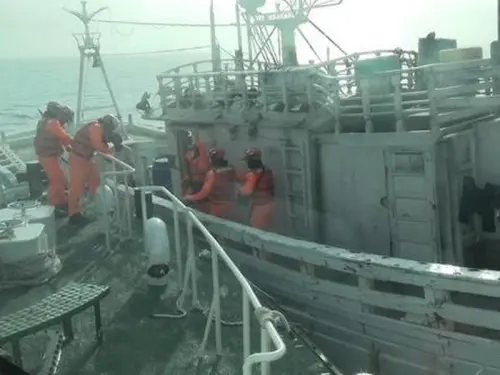 ▲海巡署人員登上漁船查獲偷渡出境通緝犯。(圖／海巡署偵防分署提供)