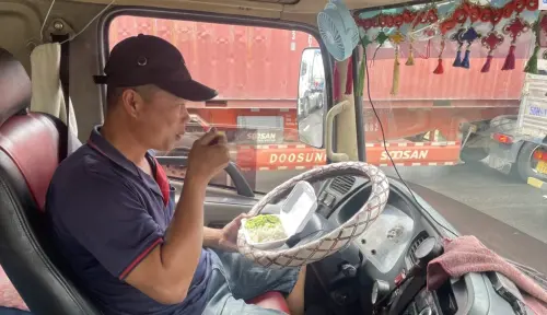 ▲貨車司機在塞車期間吃便當。（圖／翻攝自越南快訊）