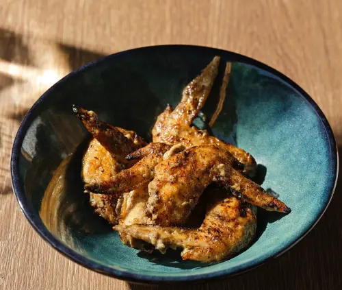 ▲「香烤雞翅」 以無糖豆漿取代傳統沙拉油與蛋黃，搭配炭烤大蔥製成的蔥香美乃滋。（圖／NÓMADA提供）