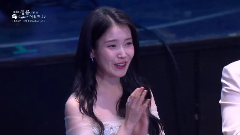 ▲南韓資深歌手崔百浩驚喜登上《青龍系列大獎》舞台表演，嚇得IU（如圖）、朴寶劍等所有入圍者通通起立。（圖／chzzk）