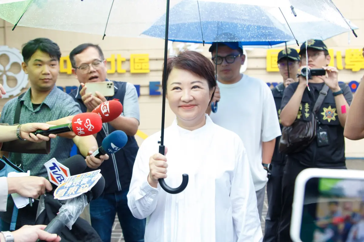 ▲台中市長盧秀燕上午撐著大傘，由隨行人員陪同到健行國小投票。（圖／台中市政府提供，2025.07.26）