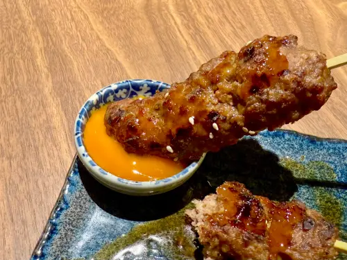 日本仙台「東山牛舌」Dream Plaza開幕!8/8買一送一菜單價格一覽 ▲炭烤牛舌丸可沾取生食級雞蛋享用。(圖/記者蕭涵云攝)