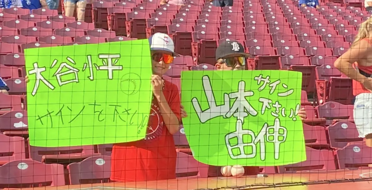▲洛杉磯道奇今（30）日於客場對戰辛辛那提紅人，場邊有2位小球迷高舉手寫日文招牌請求道奇隊上的日本球星大谷翔平與山本由伸簽名，不過卻不小心把「大谷翔平」寫成了「大谷小平」，十分逗趣。（圖／截自X）