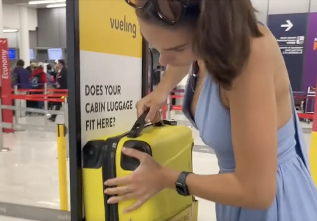 ▲一名正妹在西班牙廉航「Vueling」（伏林航空）登機前展現驚人毅力，成功將被質疑超規的行李箱「硬塞」進測量器內，過程吸引千萬網友朝聖。（圖／翻攝自TikTok＠summermken_official）